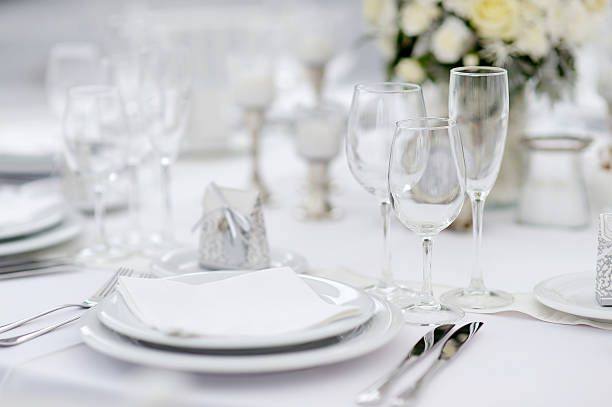 A banquet place setting with glassware and white linen