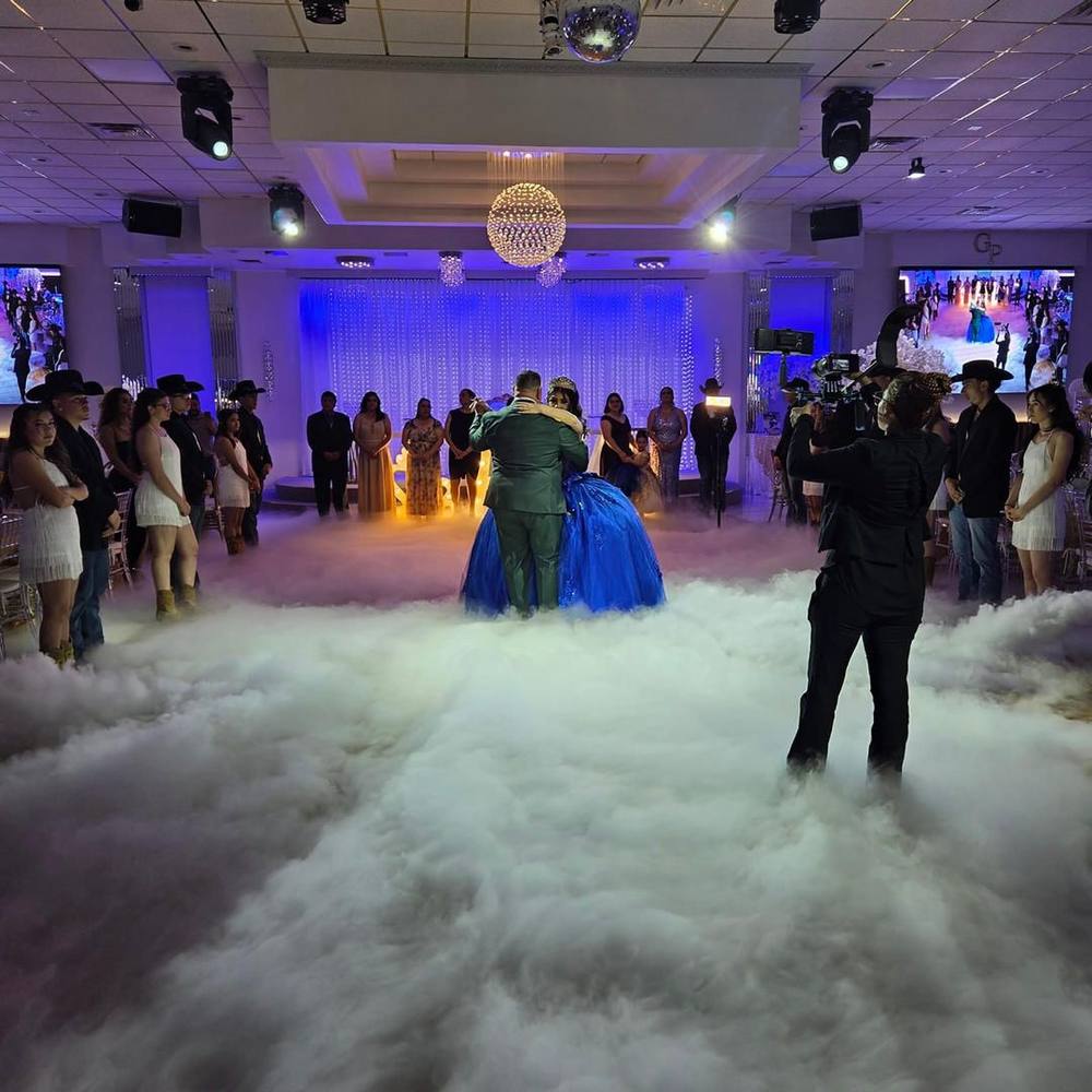 A quinceañera dancing in a cloud of low fog on the dance floor